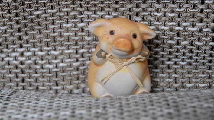 Ein kleines Porzellanschweinchen sitzt auf einem Stuhl (Quelle: rbb/OHRENBÄR/Birgit Patzelt)