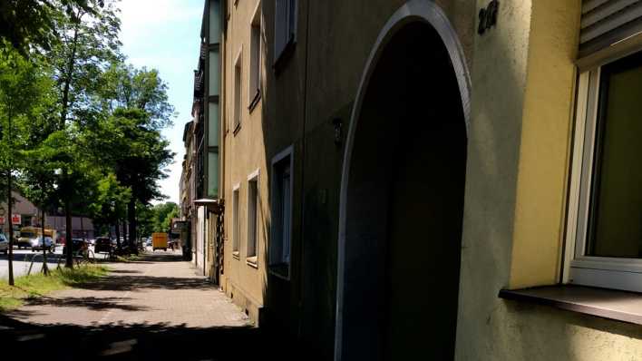 Ein Fußweg, an der Seite ein Haus mit einem dunklen Eingang mit Torbogen (Quelle: Susanne Bergmann)