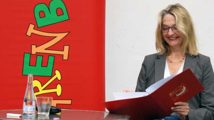 Autorin Katja Reider liest, in den Händen hält sie eine rote Lesemappe (Quelle: rbb/0HRENBÄR/Birgit Patzelt)