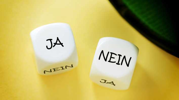 Zwei Würfel, weiß, in schwarzer Schrift auf einer Seite "Ja", auf der anderen "Nein" (Quelle: imago images/Christian Ohde)