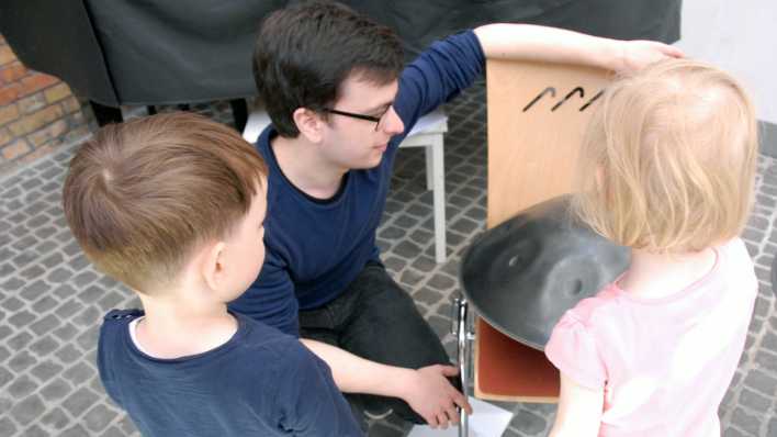 Musiker Nils Lagoda zeigt Kinder eine Handpan (Quelle: rbb/OHRENBÄR/Birgit Patzelt)