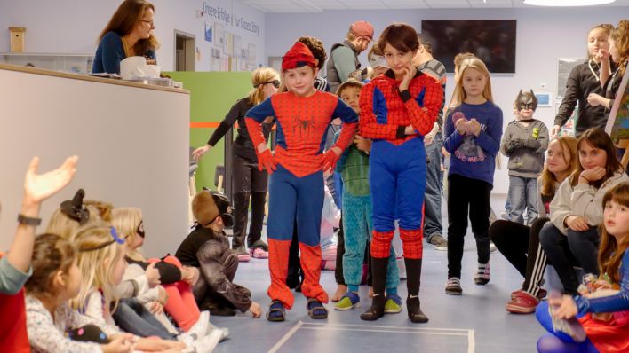 Mädchen und Jungen in Heldenkostümen stehen vor dem Helden-Parcours, gleich geht's los (Quelle: Klax Schule/Frederike Coring)