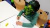Kind mit Frankenstein-Maske schreibt Urkunden (Quelle: Klax Schule/Frederike Coring)