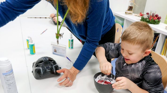 Ein Junge rührt in einer schwarzen Schale den Superabwehrschleim an (Quelle: Klax Schule/Frederike Coring)