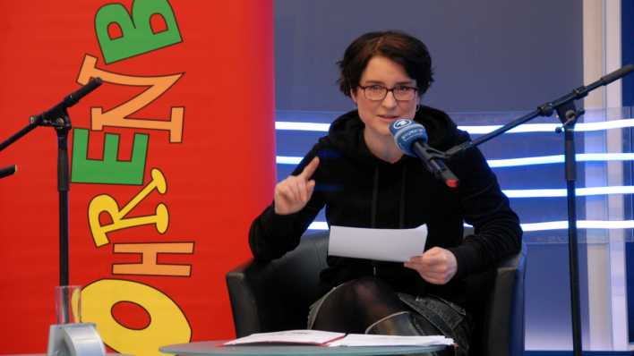 Autorin Christiane Anlauff liest und gestikuliert, im Hintergrund OHRENBÄR-Banner (Quelle: rbb/OHRENBÄR/Birgit Patzelt)