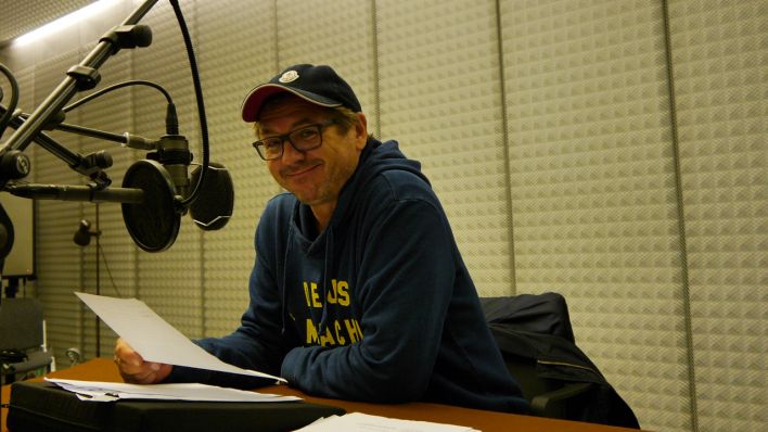 Sitzt vor dem Mikrofon im Studio: Schauspieler Andreas Fröhlich als Erzähler (Quelle: rbb/Robert Schön)