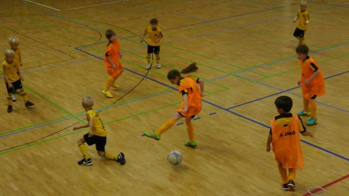 Kinder mit gelben Trikots bzw. orangefarbenen Leibchen spielen in der Sporthalle Fußball (Quelle: rbb/OHRENBÄR/Sonja Kessen)