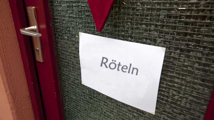 Glastür mit einem weißen Din-A-4-Blatt mit der Aufschrift "Röteln" (Quelle: imago images/Horst Rudel)