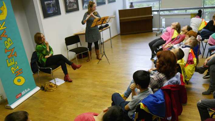 Musikerin Hanna Keller spielt Querflöte, Kinder im Publikum lauschen mit geschlossenen Augen (Quelle: rbb/OHRENBAER/Sonja Kessen)