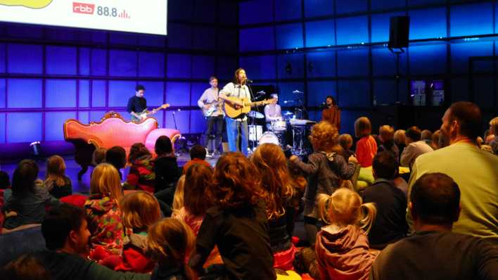 Auf der Bühne: Johannes Stankowski und seine Band, vor Kindern mit ihren Eltern (Quelle: rbb/OHRENBÄR/Sonja Kessen)