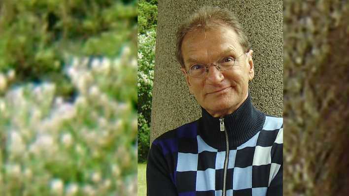 Porträt des Schauspielers Joachim Kaps, vor einem Baum, mit Rollkragenpullover und Brille (Quelle: privat)