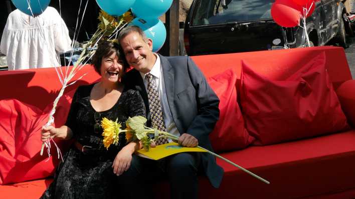 Klaus Peter Grap und Ilka Teichmüller - alias Ohrenbär & Krähe - sitzen auf der roten Couch, mit rbb 88.8-Luftballons und Blume (Quelle: rbb/OHRENBÄR/Sonja Kessen)