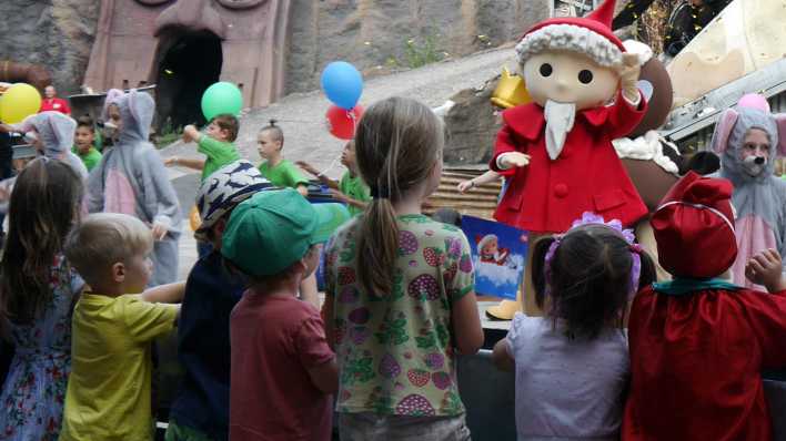 Sandmann winkt zum Publikum, viele Kinder darunter (Quelle: rbb/OHRENBÄR/Sonja Kessen)