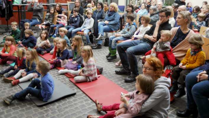 Viele Kinder und Erwachsene auf Matten und auf Stühlen, OHRENBÄR in der "Alten Schmiede" in Lichtenberg (Quelle: rbb/OHRENBÄR/Sonja Kessen)
