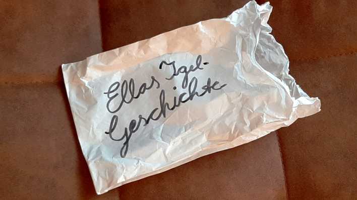 Eine weiße Brötchentüte, darauf in Schwarz geschrieben: Ellas Igel-Geschichte (Quelle: rbb/OHRENBÄR/Sonja Kessen)