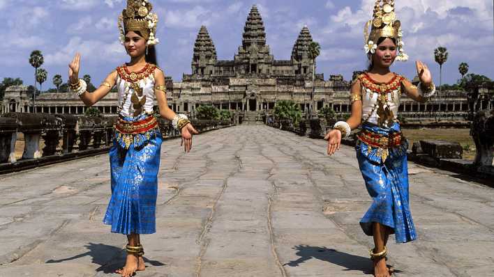 Traditionell gekleideteTänzerin, im Hintergrund die Temeplanlage von Angkor Wat (Quelle: imago/imagebroker)