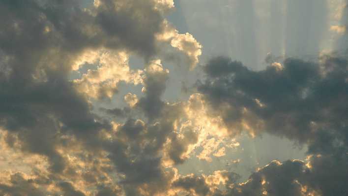 Die Sonne scheint durch einen dunklen Wolkenhimmel (Quelle: rbb/OHRENBÄR/Birgit Patzelt)