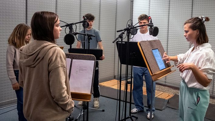 Schauspielerin Lisa Hrdina als Stella mit den Kindern vor Mikrofonen im Studio (Quelle: rbb/OHRENBÄR/Oliver Ziebe)