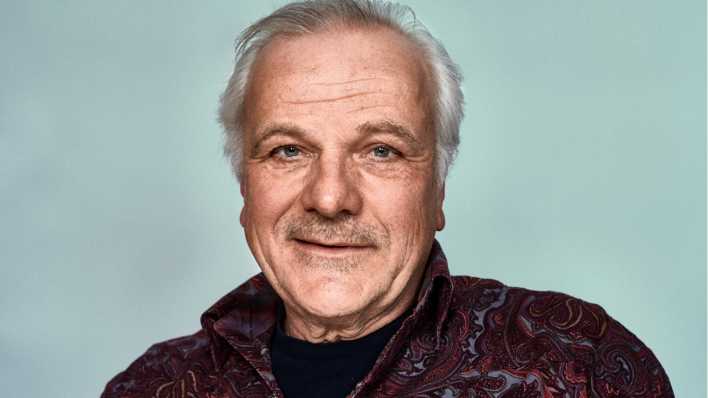 Porträt von Schauspieler Bernhard Schütz, im Hemd, vor einer hellen Wand (Quelle: Fabian Möhrke)