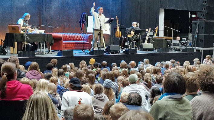 Publikum vor der Bühne, auf der Bühne Schauspieler und Musiker im Live-Hörspiel "Till Eulenspiegel" (Quelle: rbb/OHRENBÄR/Sonja Kessen)