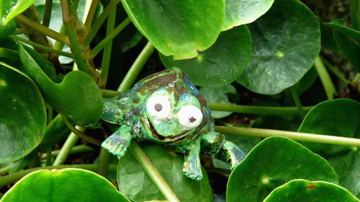 Ein bemalter Tonfrosch im Grünen (Quelle: rbb/OHRENBÄR/Sonja Kessen)