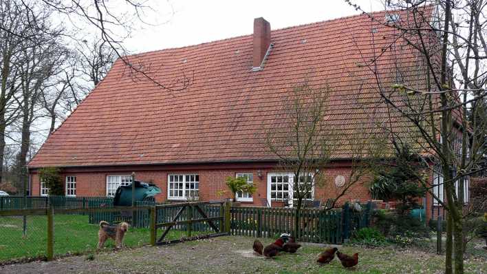 Ein zweistöckiges Haus auf dem Lande mit Garten und Tieren davor (Quelle: rbb/OHRENBÄR/Sonja Kessen)