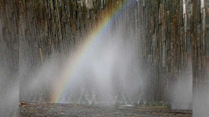 Ein Regenbogen vor einer Steinwand über Wasser (Quelle: rbb/OHRENBÄR/Birgit Patzelt)