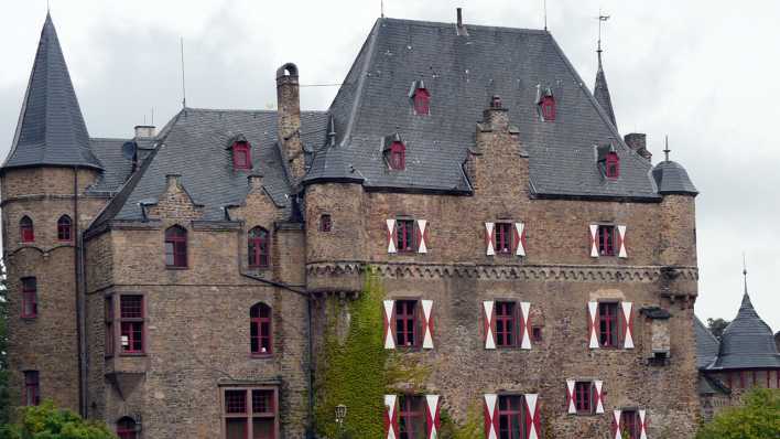 Ein großes Schloss mit Turmspitzen und roten Fensterrahmen (Quelle: rbb/OHRENBÄR/Sonja Kessen)