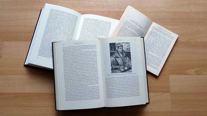 Drei Bücher liegen aufgeklappt auf einem Laminatboden (Quelle: rbb/OHRENBÄR/Sonja Kessen)