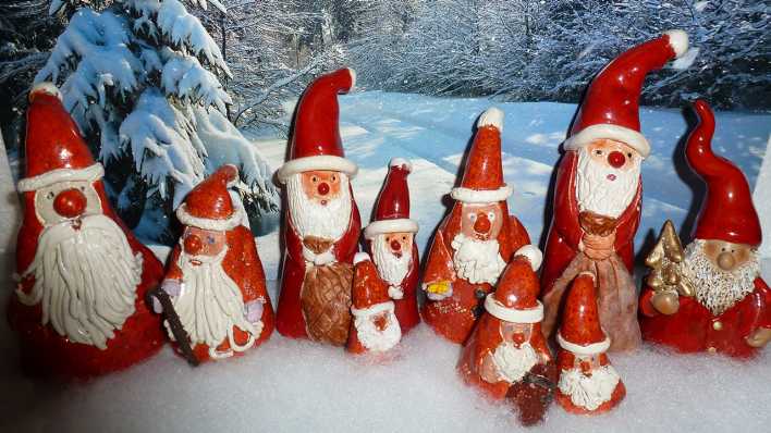 Weihnachtsmänner aus Ton, vor einer winterlichen Foto-Landschaft (Quelle: rbb/OHRENBÄR/Sonja Kessen)