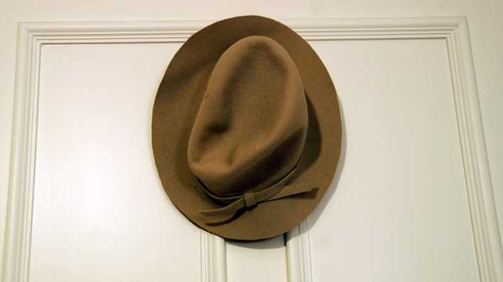 Ein eleganter brauner Hut am Haken an einer Innentür (Quelle: rbb/OHRENBÄR/Birgit Patzelt)