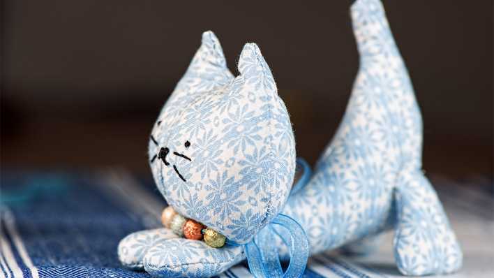 Eine handgemachte Katze aus Stoff, blau-weiß (Quelle: Colourbox)