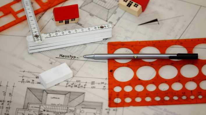 Bauplan, darauf Stift, Radiergummi, Lineale und Spielzeughäuser (Quelle: Imago/Gerhard Leber)