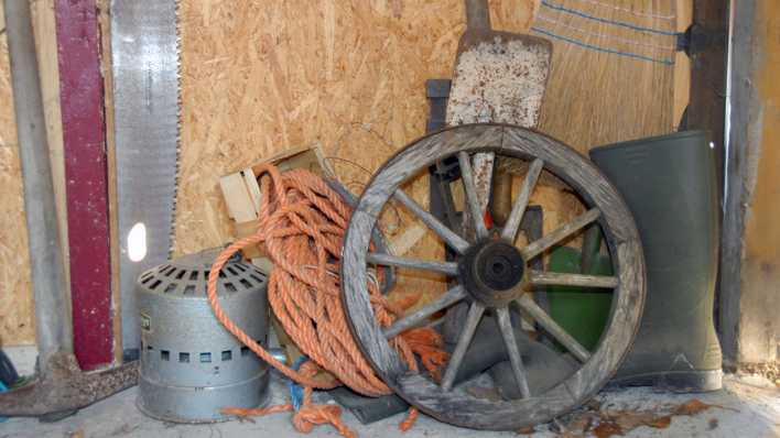 Landwirtschaftliche Geräte, vom Rad bis zum Gummistiefel, durcheinander vor einer Holzwand (Quelle: rbb/OHRENBÄR/Birgit Patzelt)