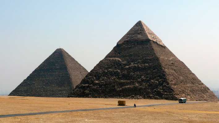Zwei große Pyramiden, im Vordergrund ein Weg mit sehr klein wirkendem Fahrzeug (Quelle: rbb/OHRENBÄR/Sonja Kessen)