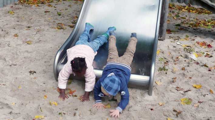 Zwei Kinder unterschiedlicher Hautfarbe liegen auf einer Rutsche (Quelle: rbb/OHRENBÄR/Sonja Kessen)
