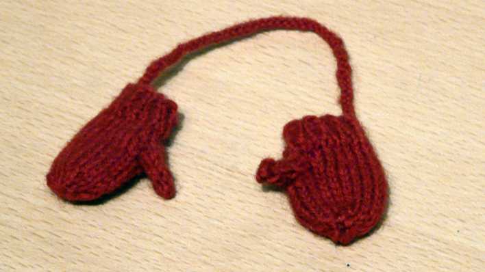 Ein paar rote Kinderhandschuhe, mit einer Schnur verbunden (Quelle: rbb/OHRENBÄR/Sonja Kessen)