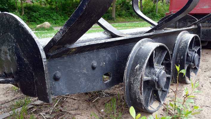 Alter Schienenwagen, abgestellt auf einem Sandboden, im Hintergrund Bäume (Quelle: rbb/OHRENBÄR/Sonja Kessen)