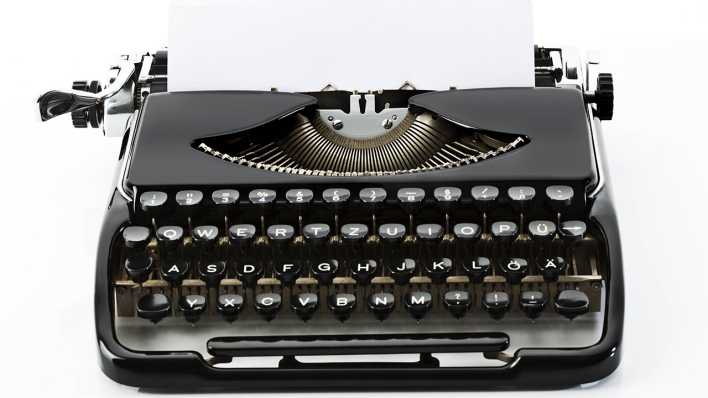 Eine alte Schreibmaschine, Papier eingespannt (Quelle: imago images/Westend61)