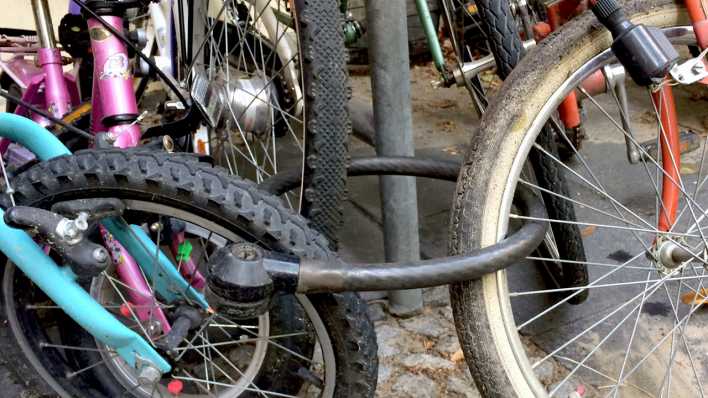 Räder von Kinderfahrrädern, mit einem Schloss verbunden (Quelle: rbb/OHRENBÄR/Birgit Patzelt)