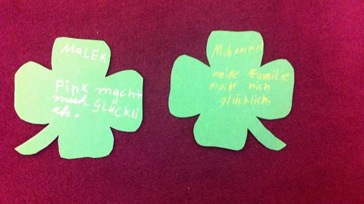 Kinderbasteleien: zwei grüne Kleeblätter auf dunkelrotem Teppichboden (Quelle: rbb/OHRENBÄR/Clara Herrmann)