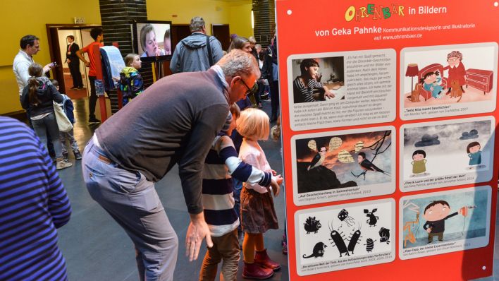 Kinder und Erwachsene vor der Wand "OHRENBÄR in Bildern" (Quelle: rbb/Oliver Ziebe)