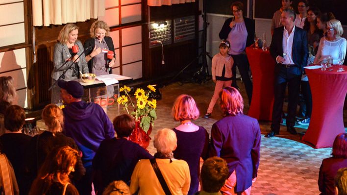 OHRENBÄR-Redakteurinnen Sonja Kessen und Birgit Patzelt mit Mikrofonen, Drumherum Publikum (Quelle: rbb/Oliver Ziebe)