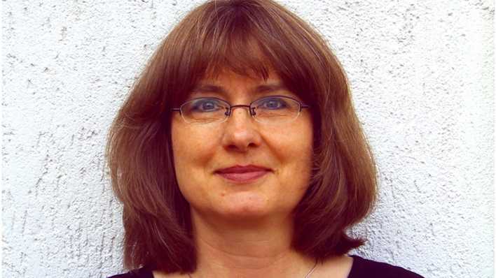 Porträt der Autorin Ingrid Annel vor einer weißen Wand (Quelle: privat)