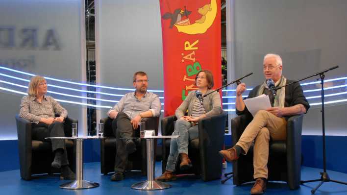 Vier Autoren auf der Bühne, im Hintergrund ein OHRENBÄR-Banner: Kristine Kretschmer, Hubert Schirneck, Ariane Grundies und Andreas Kaufmann (Quelle: rbb/OHRENBÄR/Birgit Patzelt)