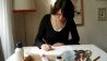 Illustratorin Daniela Bunge am Arbeitstisch, sie zeichnet, auf dem Tisch Stifte, Papier und Farben (Quelle: rbb/OHRENBÄR/Alja Mai)