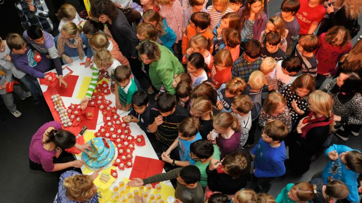 Kinder holen sich ein Stück von der großen Geburtstagstorte, Blick von oben © Thomas Ernst