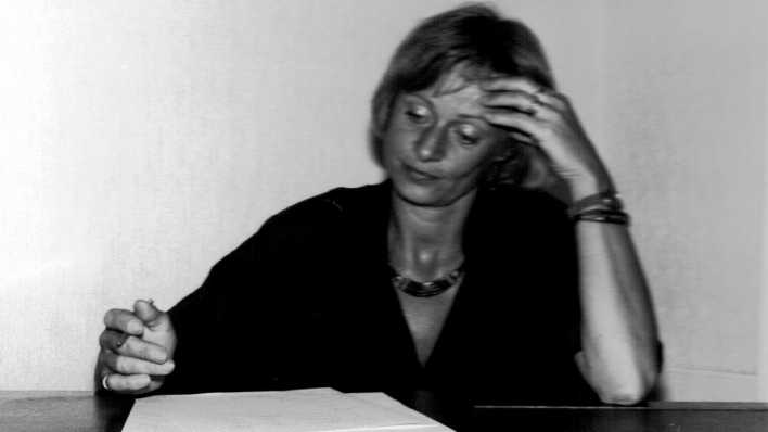 Porträtaufnahme der Autorin Elke Hermannsdörfer in schwarz-weiß, schreibend am Tisch (Quelle: privat)