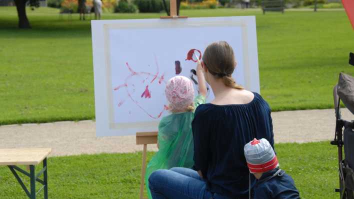 Eine Mutti mit zwei Kindern vor der Staffelei, ein Mädchen malt ein Bild (Quelle: rbb/OHRENBÄR/Birgit Patzelt)