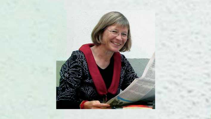 Porträt der Autorin Kristine Kretschmer mit Zeitung, lesend am Tisch (Quelle: privat)